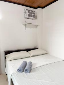 a bedroom with a bed with two towels on it at Shiloh Homestay in General Luna