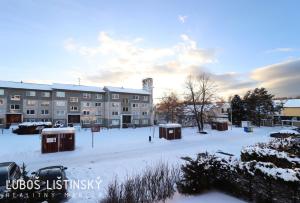 a snow covered parking lot in front of a building at Apartman Pod Vysokymi Tatrami in Nová Lesná