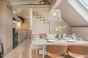 a dining room with a table and chairs and a kitchen at 529-Lemvig-Lokkevej-61-A in Lemvig