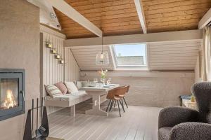 a living room with a table and a couch and a fireplace at 529-Lemvig-Lokkevej-61-A in Lemvig +12 photos