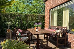 a wooden table and chairs on a patio at Santos in Noordwijk aan Zee
