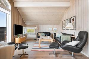 a living room with black chairs and a tv at 392-Harboore-Fourmivej-64 in Harboør