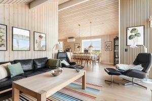 a living room with a couch and a table and chairs at 392-Harboore-Fourmivej-64 in Harboør