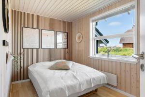 a small bedroom with a bed and a window at 392-Harboore-Fourmivej-64 in Harboør