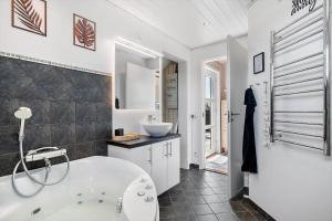 a white bathroom with a tub and a sink at 392-Harboore-Fourmivej-64 in Harboør +24 photos