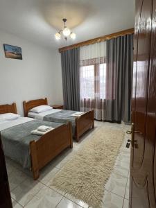 a hotel room with two beds and a window at Camping & Guest House Herges in Udënisht