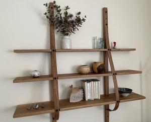 a wooden shelf on a wall with books at 16 Manesty View in Keswick