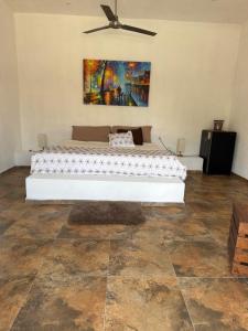 a bed in a room with a painting on the wall at Corazón zen in Barra de Potosi
