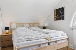 a bedroom with a large bed with a wooden frame at 0457-Romo-Vestergade-119-App-57 in Høm +26 photos