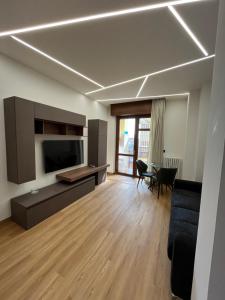 a living room with a television and a couch and a table at Alloggio Manzoni in Asti