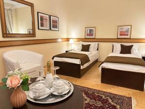 a hotel room with two beds and a table with a plate on it at FLEUR DE LIS HOTEL in Prague