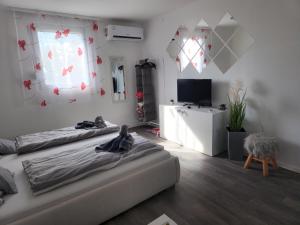 a bedroom with two beds and a flat screen tv at Tündérlak Nyaraló Békésszentandrás in Békésszentandrás