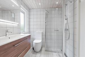 a white bathroom with a toilet and a shower at 0127-Romo-Umanaksvej-4 in Høm +11 photos