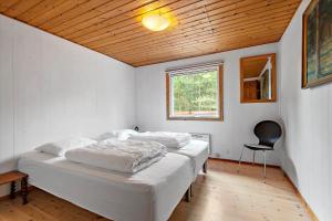 a bedroom with a bed and a chair in it at 0127-Romo-Umanaksvej-4 in Høm