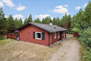 a red cabin in the middle of a forest at 0127-Romo-Umanaksvej-4 in Høm