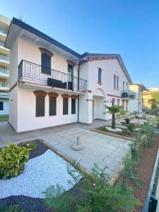 a large white house with a pond in front of it at Casette Baradel - Agenzia Caorle in Caorle