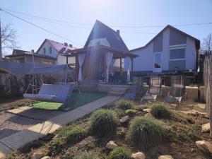 a backyard with a swing and a house at Tündérlak Nyaraló Békésszentandrás in Békésszentandrás