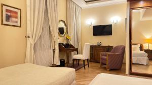 a hotel room with a bedroom with two beds and a desk at FLEUR DE LIS HOTEL in Prague