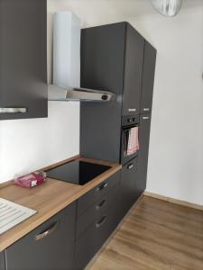 a kitchen with black cabinets and a wooden counter top at Brunate Funicolare Apartament in Brunate