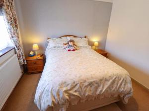 a teddy bear sitting on a bed in a bedroom at Seascape in Hunstanton