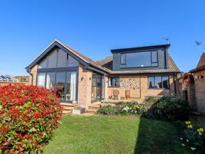 a brick house with large windows and a yard at Seascape in Hunstanton