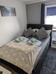 a bed with pillows on it in a bedroom at Stadtnah an der Förde 5502 in Flensburg