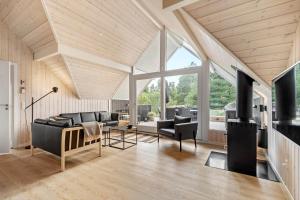 a living room with black furniture and a large window at 0218-Romo-A-Hveyselsvej-13 in Høm