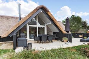 a house with a thatched roof with a patio at 0218-Romo-A-Hveyselsvej-13 in Høm