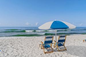 two chairs and an umbrella on a beach at Spanish Key 304 in Perdido Key