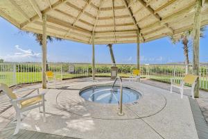 a patio with a hot tub under a wooden umbrella at Spanish Key 304 in Perdido Key
