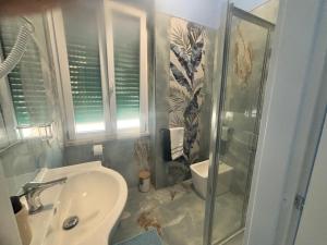 a bathroom with a shower and a sink and a toilet at Tower casa vacanze 2 in Anzio +17 photos