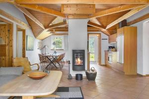 a living room with a fireplace and a table at 0326-Romo-Sandloberen-3 in Høm