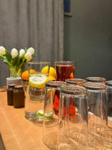 a wooden table with several glasses of liquids and flowers at Apple Economy Hotel in Kaunas