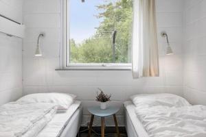 two beds in a room with a window and a stool at 0167-Romo-Julianehab-12 in Høm