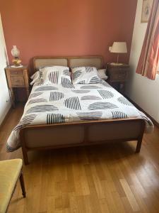 a bed in a bedroom with two night stands and two tables at Pavillon in Beaufay