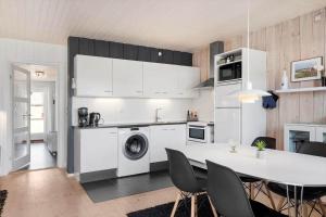 a kitchen with white cabinets and a table with chairs at 0421-Romo-Vestergade-3-Ap-34 in Høm