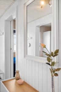 a bathroom with a mirror and a vase on a table at 0421-Romo-Vestergade-3-Ap-34 in Høm +24 photos