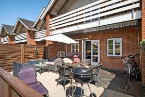 a patio with a grill and a table and chairs at 0421-Romo-Vestergade-3-Ap-34 in Høm