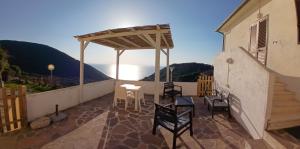a patio with chairs and a table on a balcony at Sunset House in Mortigliano