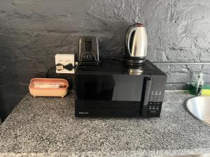 a microwave on a counter with a coffee maker on it at Blue Moon Charming 2 Bed Poolside Apartment in Bellville