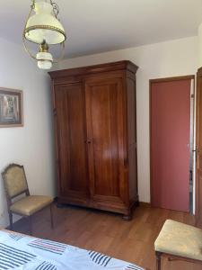 a room with a wooden cabinet and a chair at Pavillon in Beaufay