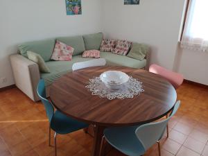 a dining room table with chairs and a couch at Sunset House in Mortigliano