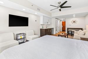 a bedroom with a white bed and a living room at Lasata #3112 in Destin
