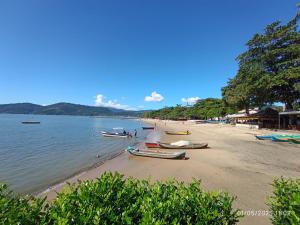 a beach with boats on the sand and water at Casa Lego Paraty in Paraty