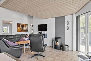 a living room with a couch and a table and a fireplace at 0403-Romo-Lyngvejen-44-C in Høm
