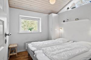 a bedroom with two beds and a window at 0403-Romo-Lyngvejen-44-C in Høm