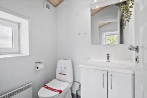 a white bathroom with a toilet and a sink at 0403-Romo-Lyngvejen-44-C in Høm +13 photos