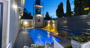 a swimming pool in the backyard of a house at night at Elle Apartments in Lusaka