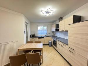 a kitchen with a wooden table and chairs in it at Asiatisches Ferienhaus in Merseburg