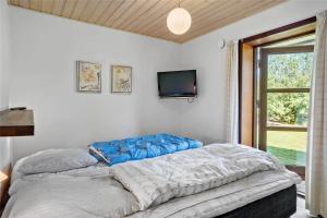 a bedroom with a bed and a tv on the wall at 0335-Romo-Vestergardsvaenget-2 in Høm